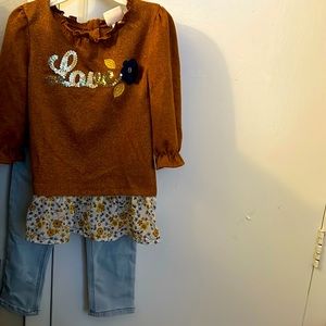 Brown long sleeve shirt that says “Love” in beautiful gold.
